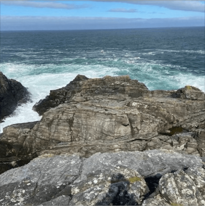 Sea with waves crashing onto a rocky shore.